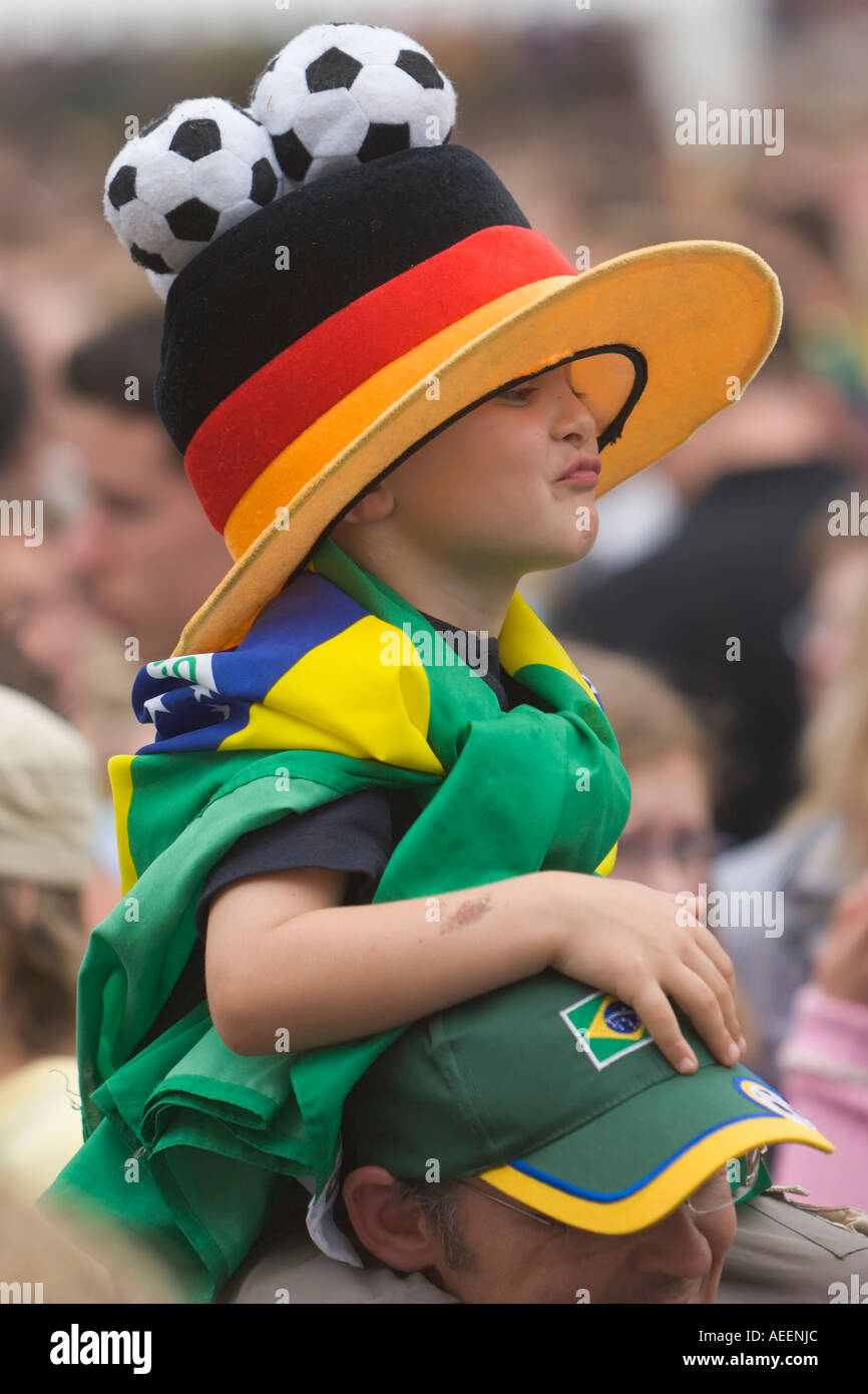 Jungen Fußball-Fan mit deutsch-brasilianischen Outfit, sitzen auf seines Vaters Schultern bei einem public-Viewing-event Stockfoto