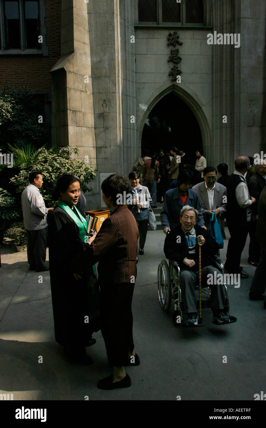 Die Priesterin grüßt die Gemeindemitglieder nach dem Gottesdienst in der Mu En katholische Kirche in Shanghai Stockfoto