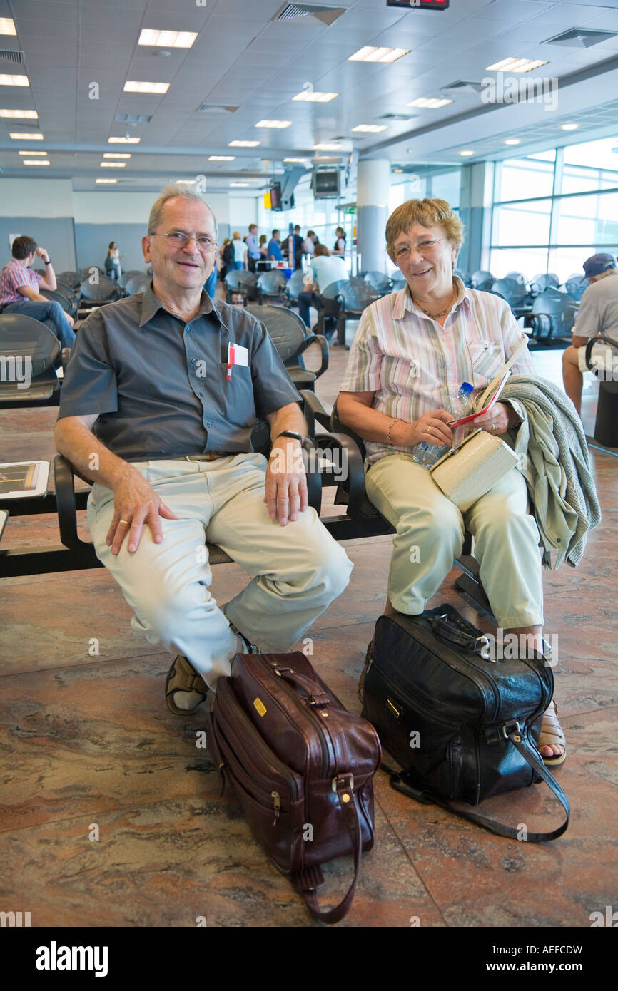 Ein älteres Ehepaar warten auf Abfahrt auf dem Praha Ruzyne International Airport in der Tschechischen Republik Stockfoto