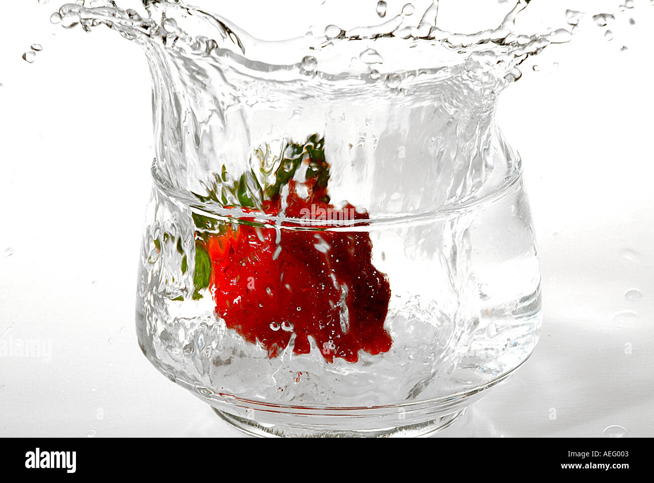 Flüssige II Erdbeer Spill Drop Droping rote Frucht transparent Dessert klar Essen Wasserglas Stockfoto