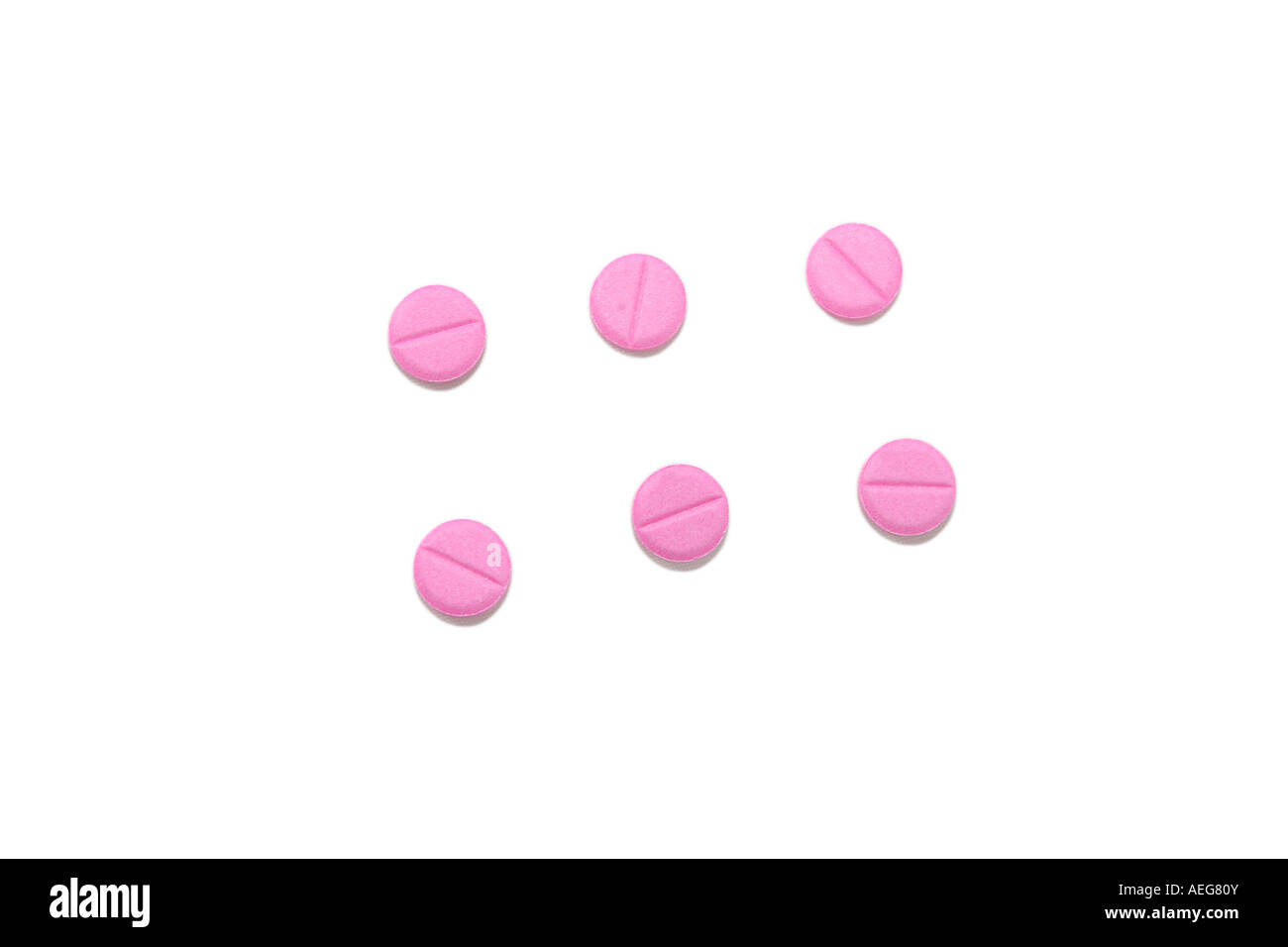 sechs kleine rosa Pillen isoliert auf weiß Stockfoto