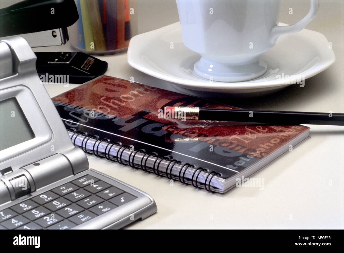 Büro-Rechner Hefter Adresse Buch Untertasse Tasse Bleistift Kommunikation Business-Konzept Stockfoto