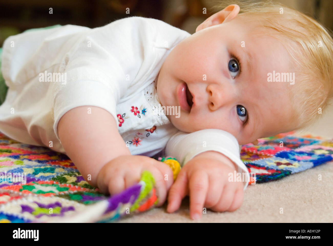 Horizontale Nahaufnahme Portrait eines sechs Monate alten kaukasischen Baby Mädchen wälzen auf dem Boden Stockfoto