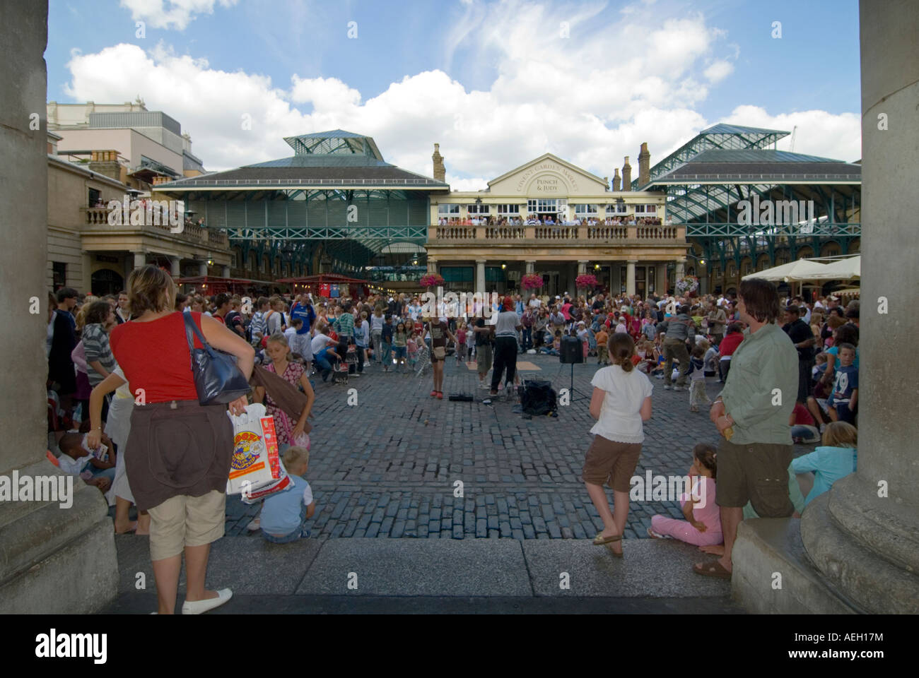 Horizontalen Weitwinkel ein Straßenkünstler unterhalten die Massen auf der Piazza in Covent Garden an einem sonnigen Abend Stockfoto