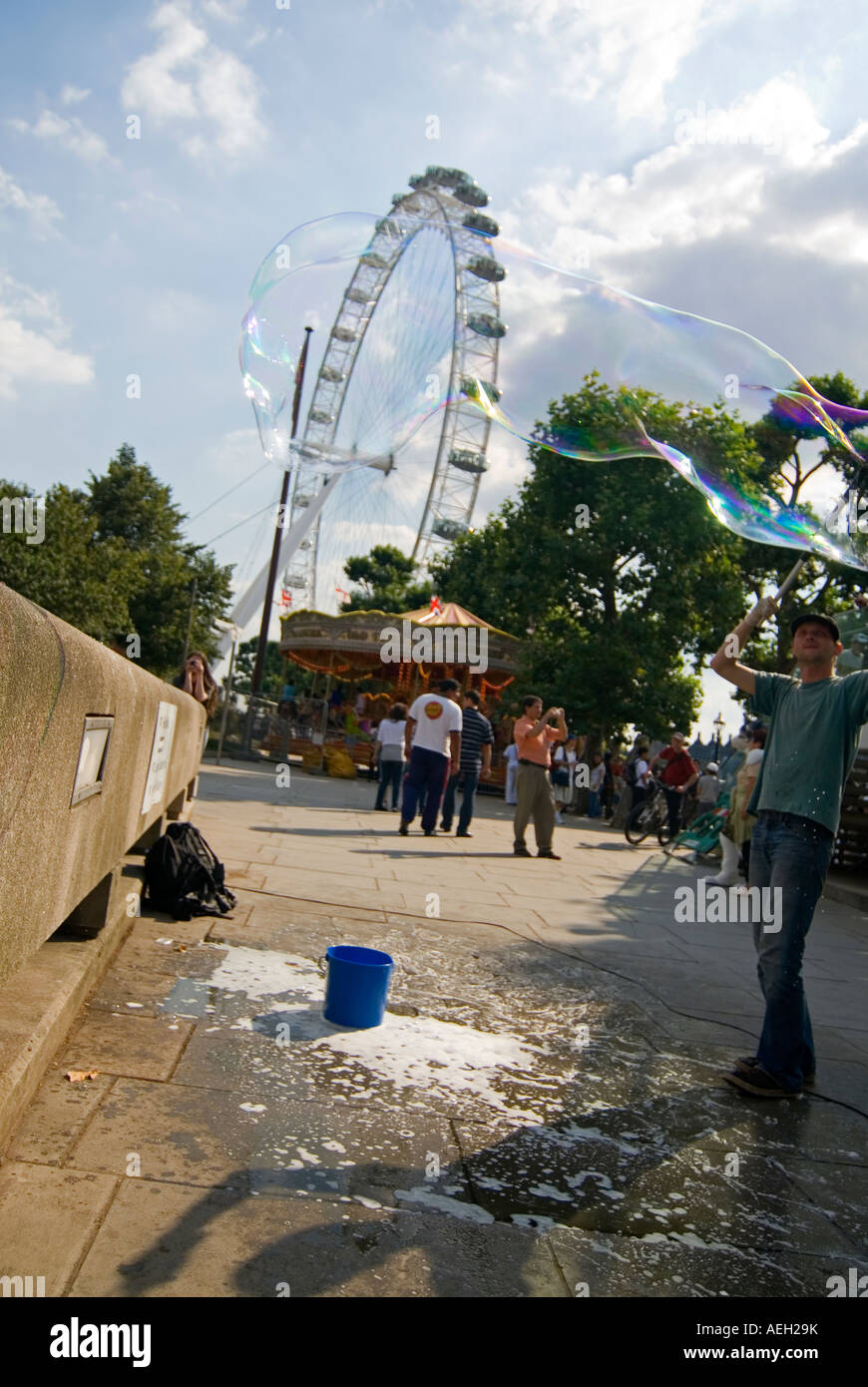 Vertikale Ansicht der Straßenkünstler erstellen riesige Luftblasen in der Sonne Stockfoto