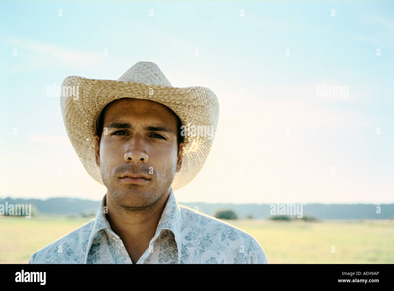 Stattliche Hispanic Mann Ende 20 in Feld in einem Cowboyhut Stockfoto