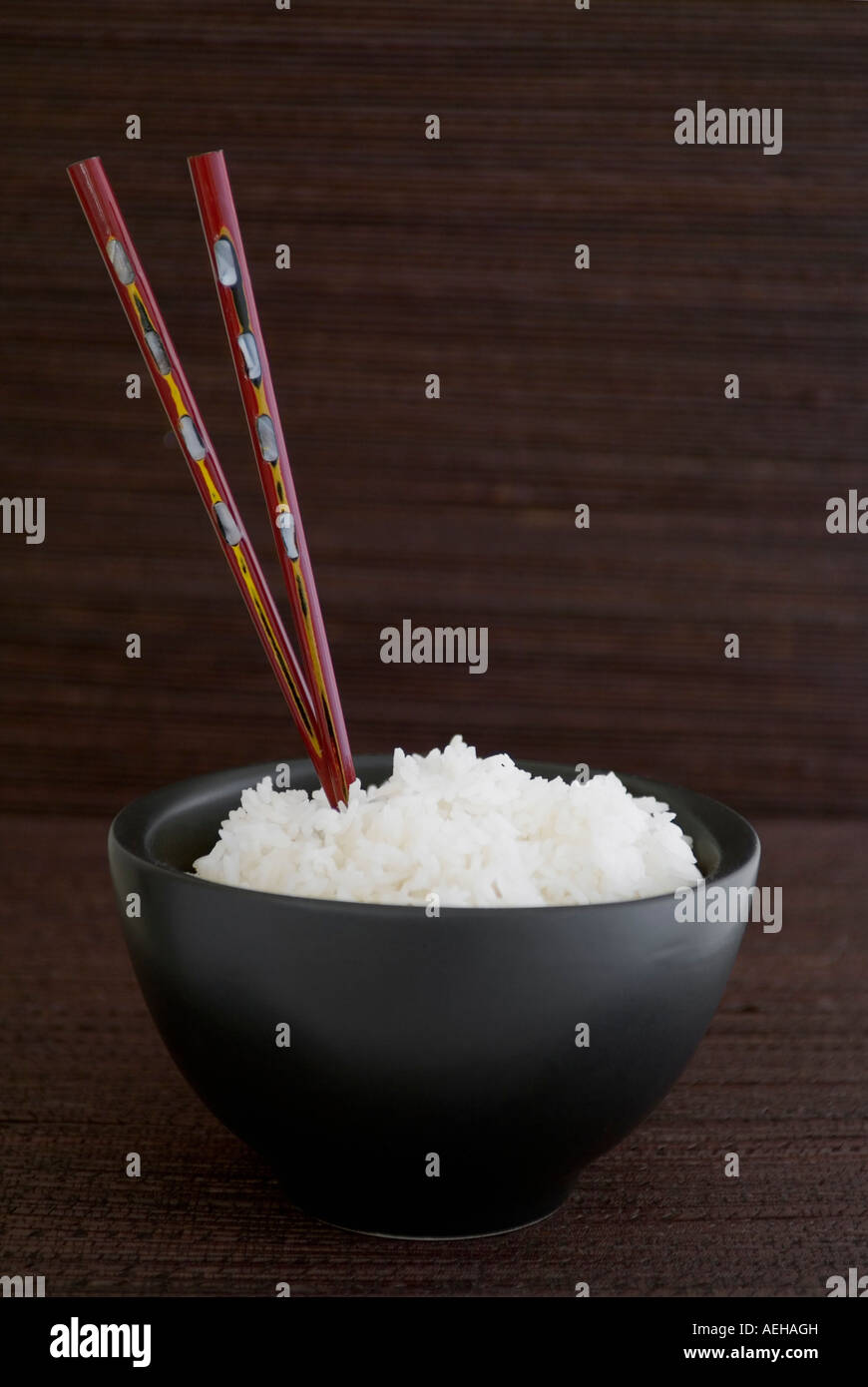 Schüssel Reis mit Stäbchen Stockfoto