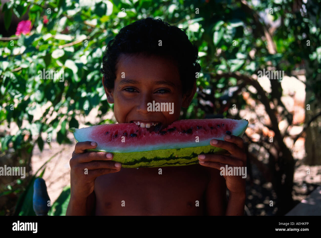 Mexikanische lächelnden jungen Essen Wassermelone von Coastal Zone von Mexiko Stockfoto