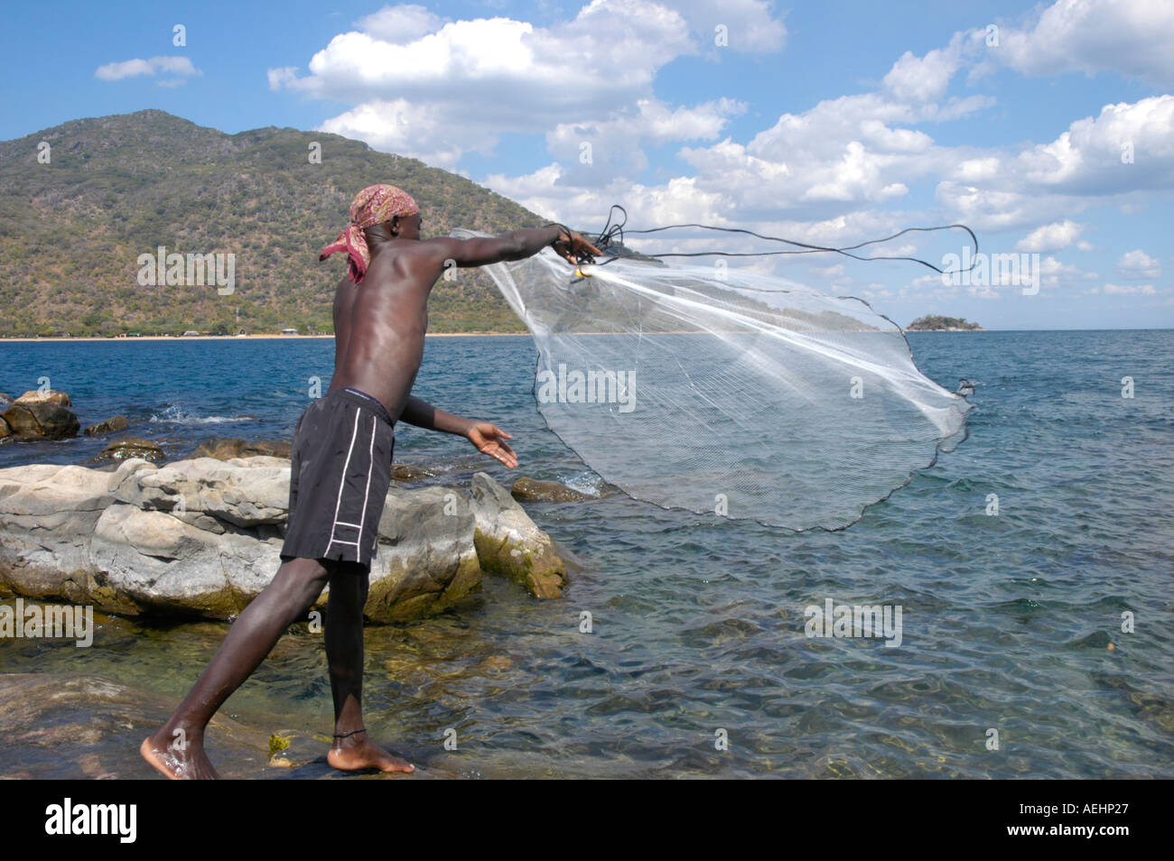 Afrikanischer Mann Angeln am Ufer des Lake Malawi ein Netz Stockfoto