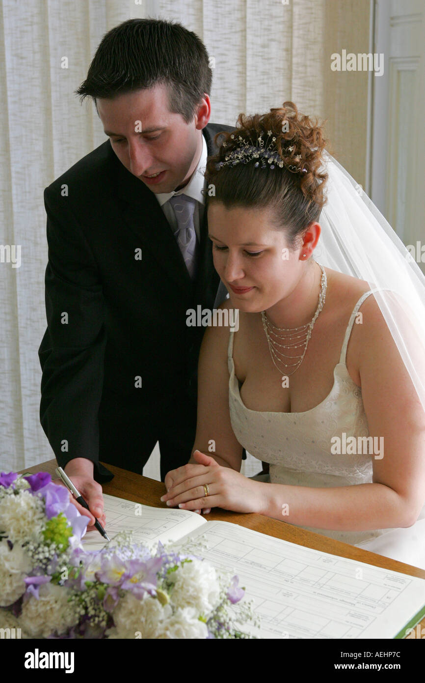 Frisch verheiratete Mann und Frau unterzeichnen die Hochzeit Register in einem typischen standesamtliche Trauung Standesamt England Großbritannien UK GB Stockfoto