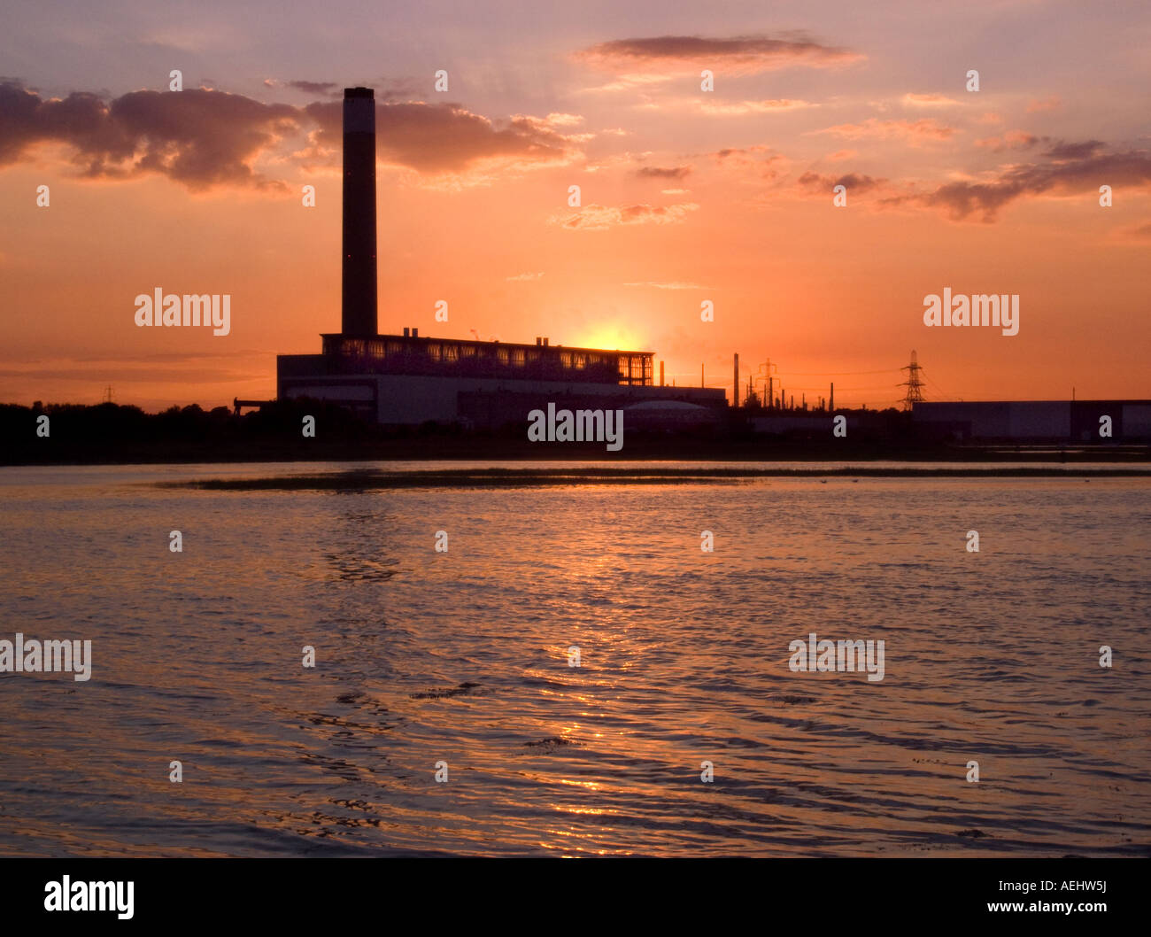 Sonnenuntergang in Fawley Power Station betrachtet von Southampton Water mit Raffinerie im Hintergrund. Stockfoto