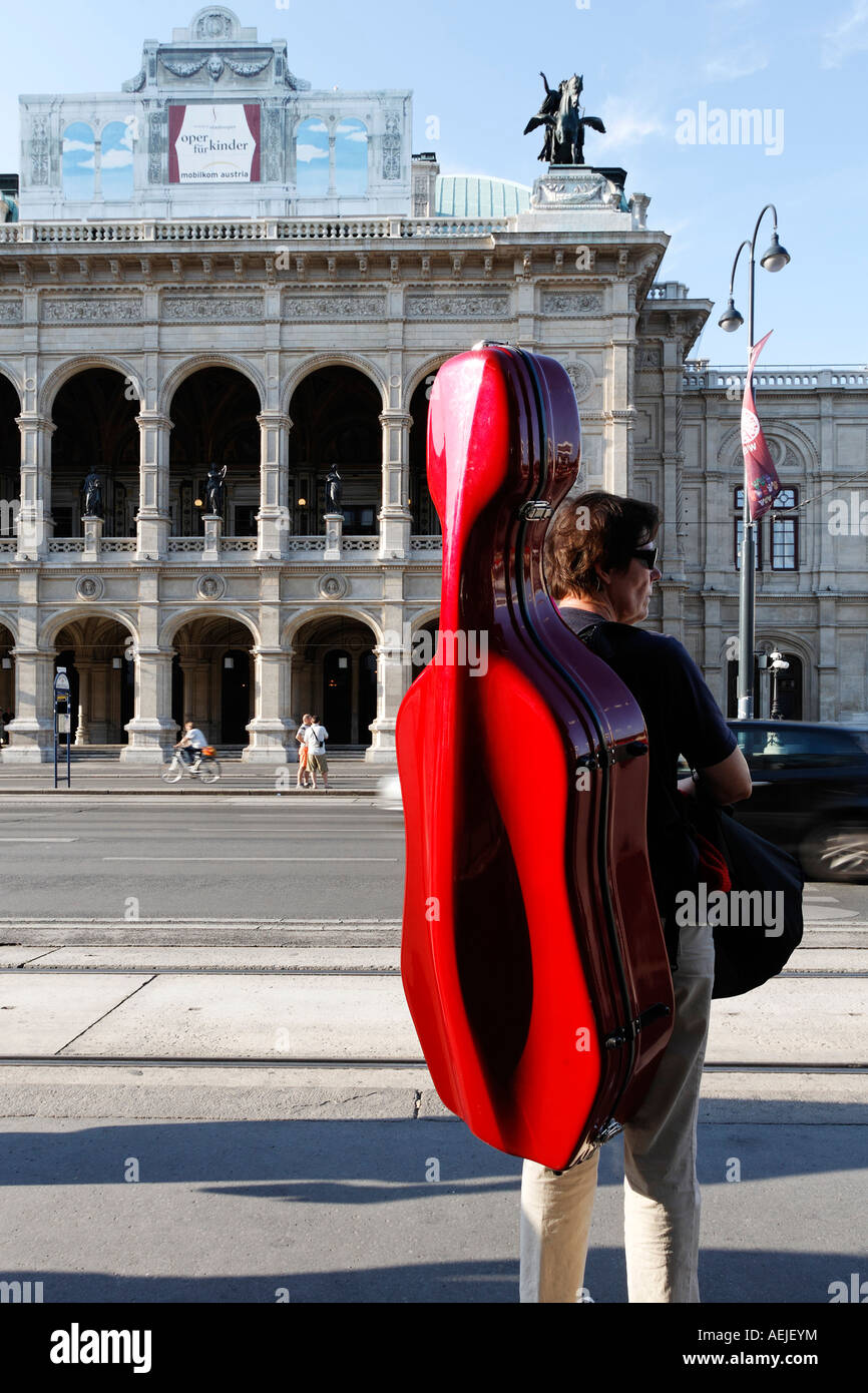 Frau mit Cellokasten warten am Bahnhof vor der Staatsoper, Wien, Österreich Stockfoto