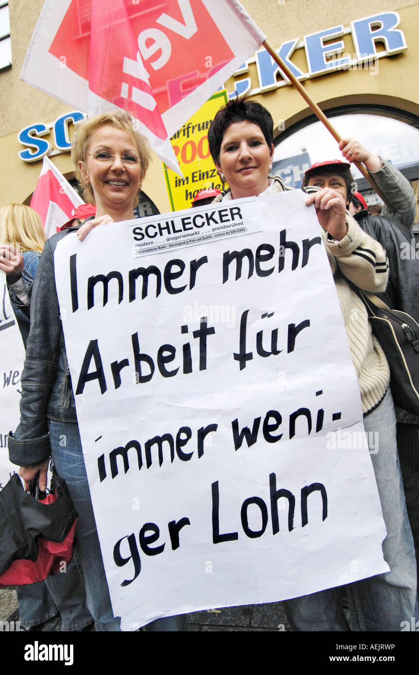 Zeichen: "mehr Arbeit für weniger Lohn. Demonstrant vor Schlecker. Stockfoto