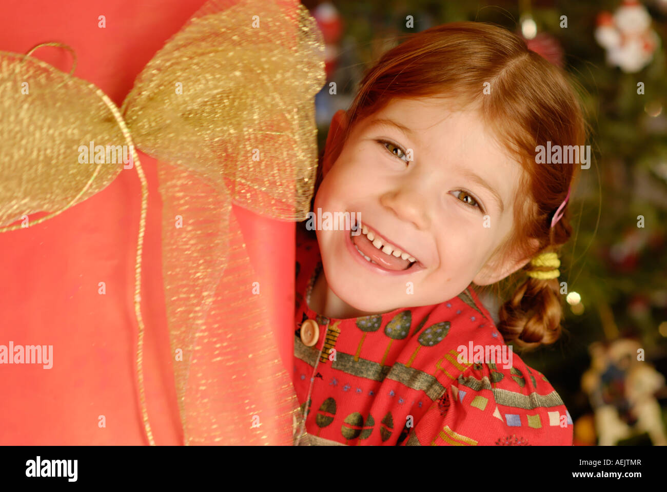 Kind freut sich über ein Weihnachtsgeschenk unter dem Weihnachtsbaum Stockfoto