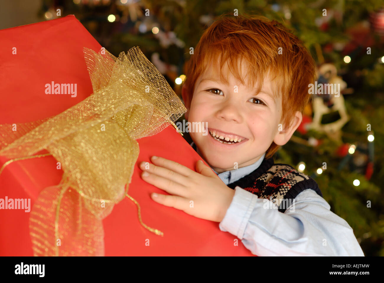 Kind freut sich über ein Weihnachtsgeschenk unter dem Weihnachtsbaum Stockfoto