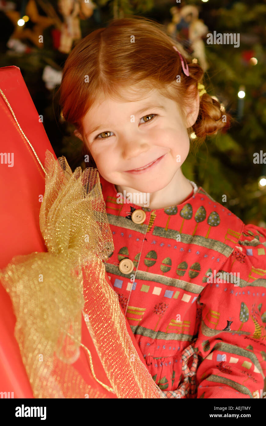 Kind freut sich über ein Weihnachtsgeschenk unter dem Weihnachtsbaum Stockfoto