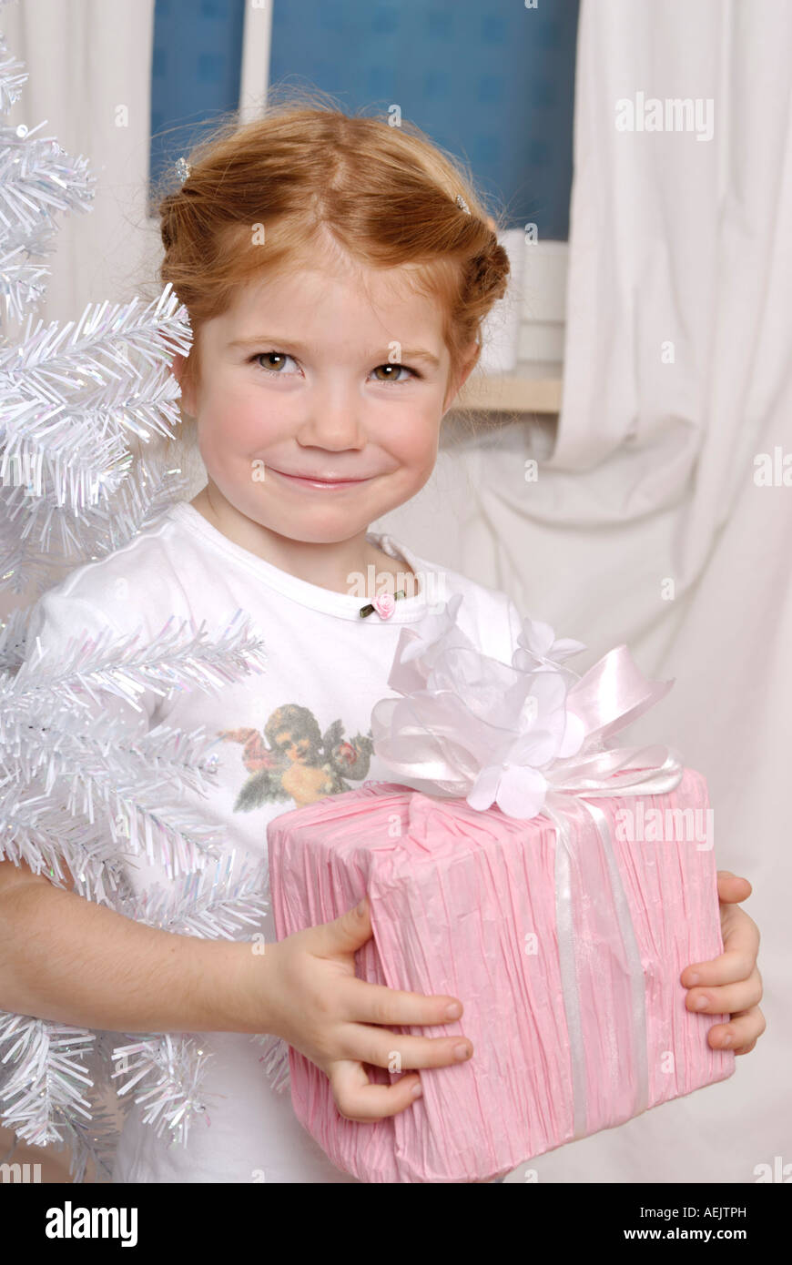Kind freut sich über ein Weihnachtsgeschenk unter dem Weihnachtsbaum Stockfoto