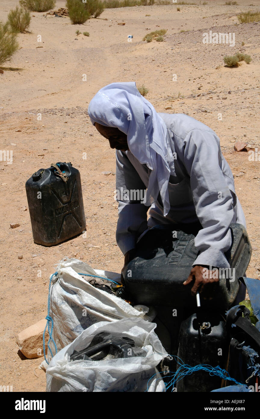 Ein Nachfüllen von Wasser in ein Kunststoff-Kanister in Wüste Sinai Ägypten ägyptischen Beduinen-Mann Stockfoto