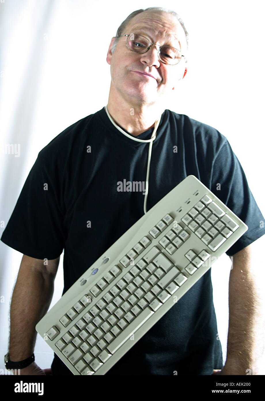 Mann im Alter von sechzig mit Tastatur um den Hals Stockfoto