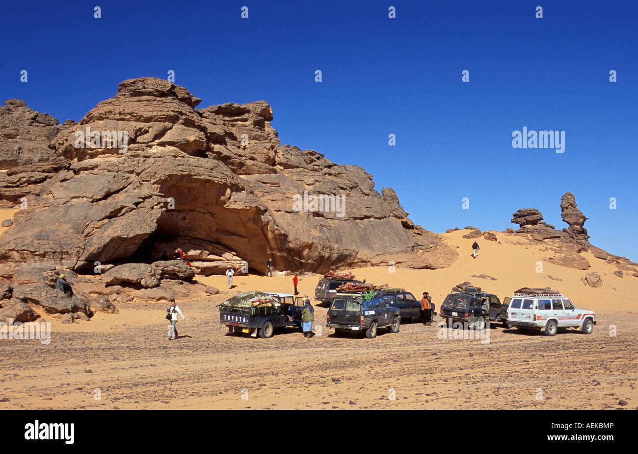 Libyen Akakus, Touristenfahrzeuge Felsen in der Wüste Sahara. Touristen auf der Suche auf prähistorischen Felsmalereien Kunst Stockfoto