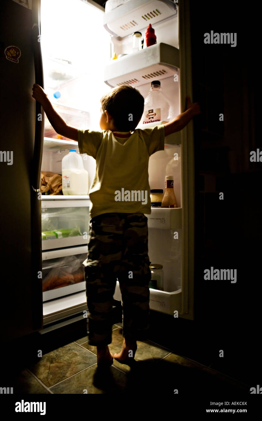 Kind sucht Kühlschrank Stockfoto