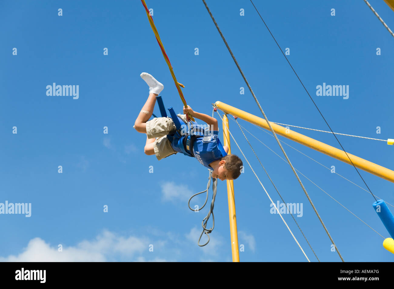 ILLINOIS Grayslake Young Boy Salto auf Bungee-hüpfen Schaukeln im Lake County Fair Sicherheitsgurt und Seile Stockfoto