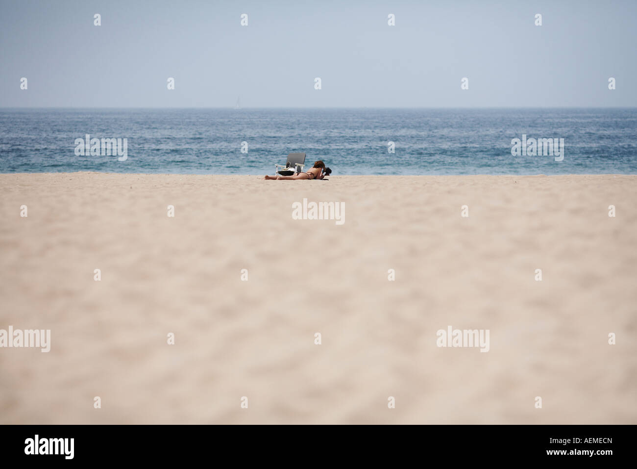 Frau, die Verlegung in Sand in Manhattan Beach, Los Angeles County, Kalifornien, USA Stockfoto