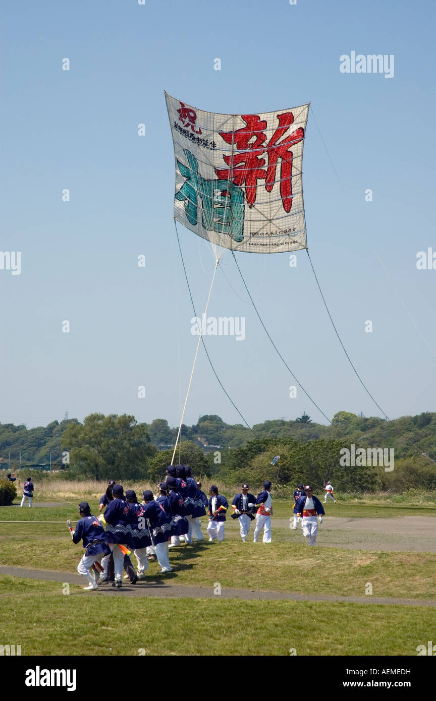 Eine Gruppe von Teilnehmern starten einen Drachen auf dem Sagamihara Riesen Kite Festival, Kanagawa, Japan Stockfoto