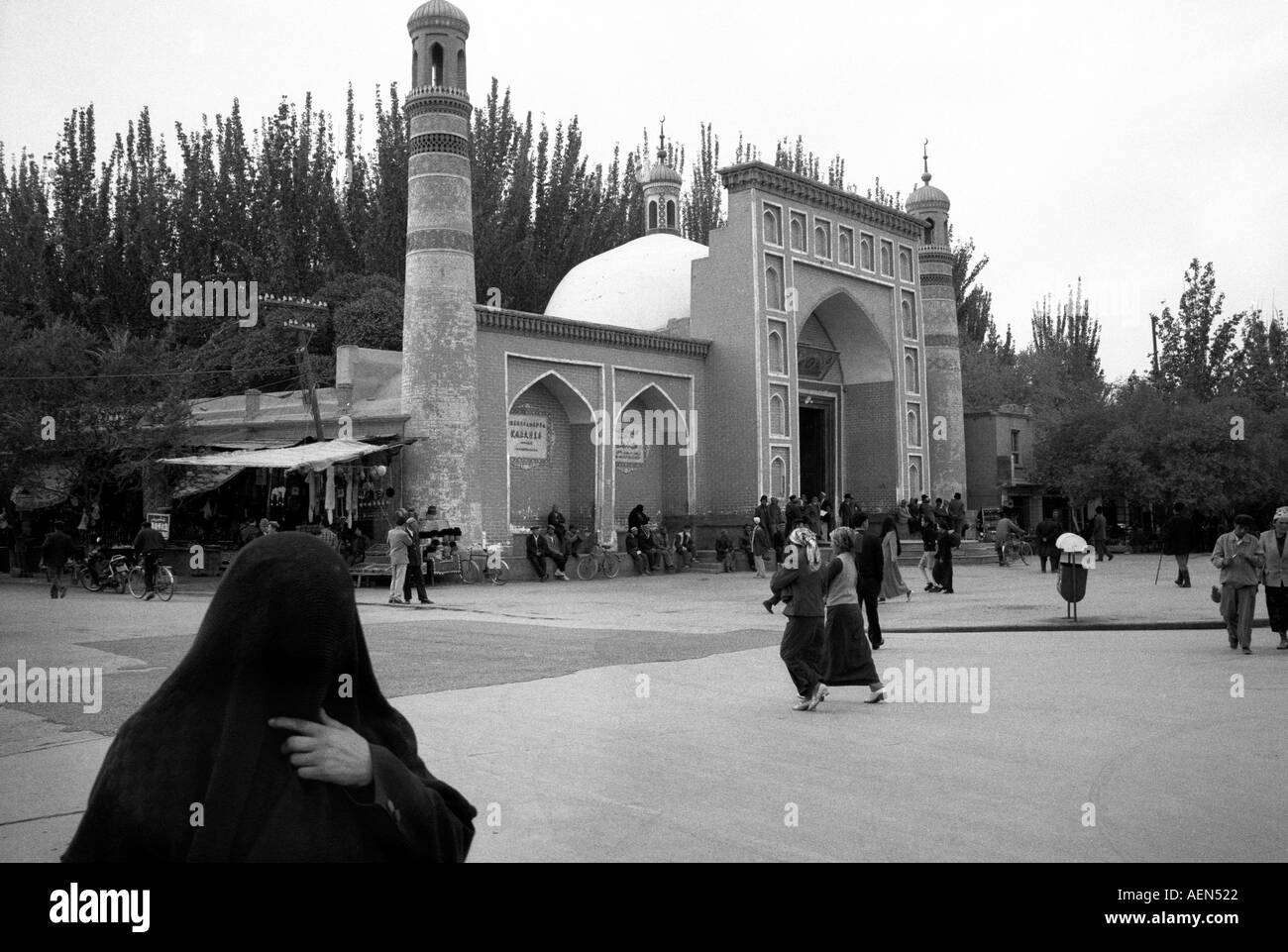 Muslimische Frau geht mit einem Schleier an der ID Kah vorbei. Die ID Kah Moschee in Kashgar die größte Moschee in China. Stockfoto