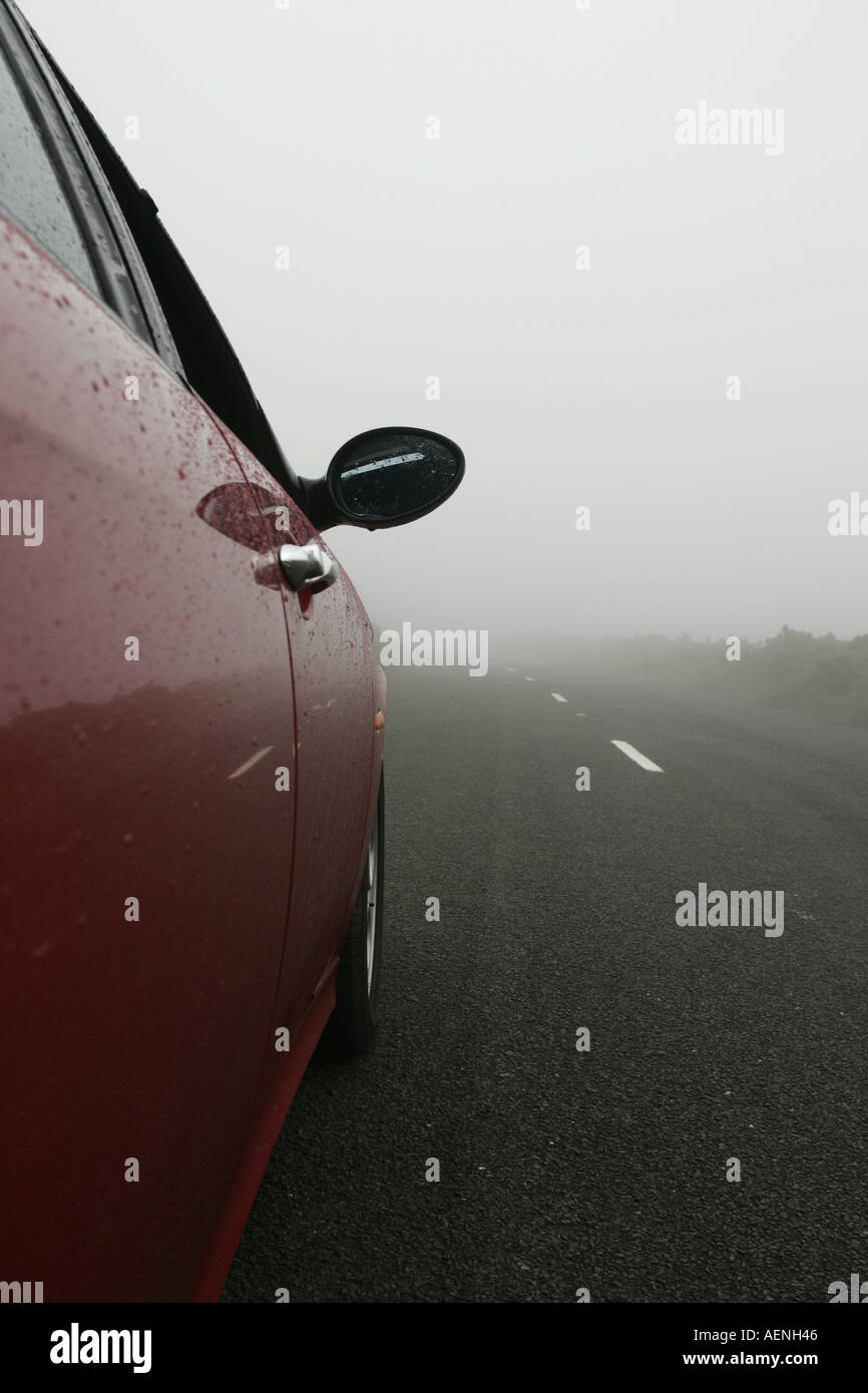 roten Alfa Romeo 156 Auto Rubrik entlang Landstraße Berg eingehüllt in Nebel Nebel IOM Stockfoto