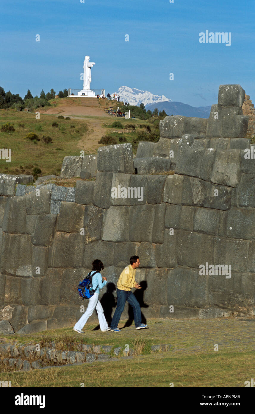 Inkaruinen Sacsayhuaman, Touristen, Statue von Jesus Christus und Ausangate Berg hinter, in der Nähe von Cusco, Peru Stockfoto
