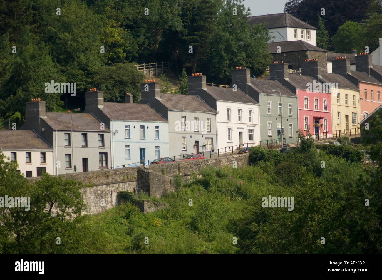 Reihe von ziemlich Pastell farbigen viktorianischen Reihenhäusern auf dem Hügel in der Sonne Llandeilo Carmarthenshire Wales UK Stockfoto