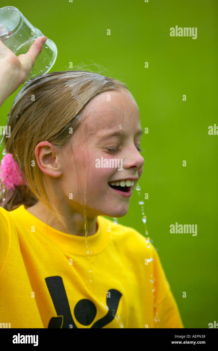 junges Mädchen nach einem Rennen mit Wasser abkühlen Stockfoto