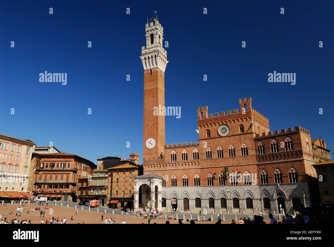 Rote Ziegel von der Palazzo Pubblico mit Turm des Mangia und Piazza Square in Siena vor einem strahlend blauen Himmel Stockfoto