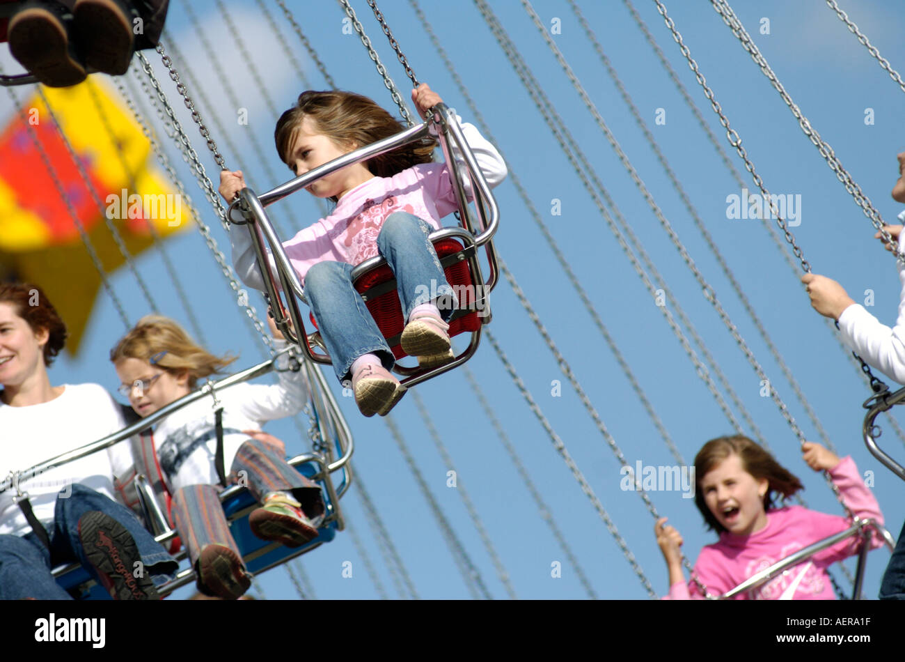 Kleine Mädchen fliegen in der Kette Stuhl merry go round Stockfoto