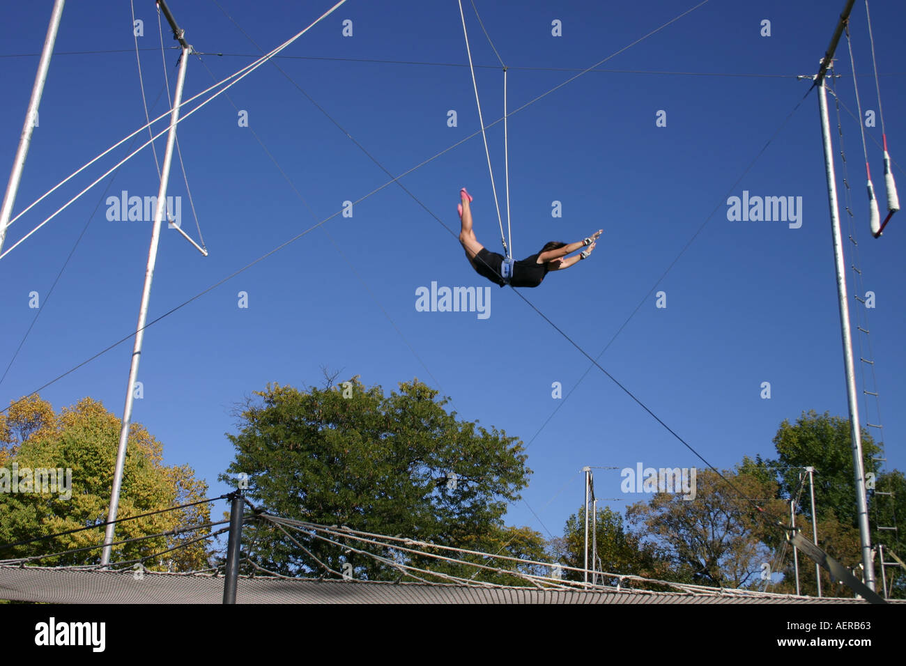 Frau Trapezkünstler fliegt über das Netz Stockfoto