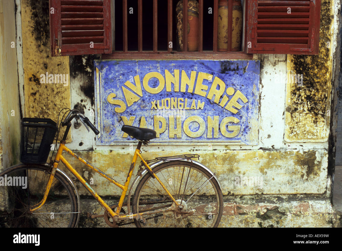 Alten verwitterten Savonnerie Xuong Lam Xa Phong Zeichen und gelben Fahrrad in Hoi an, Vietnam Stockfoto