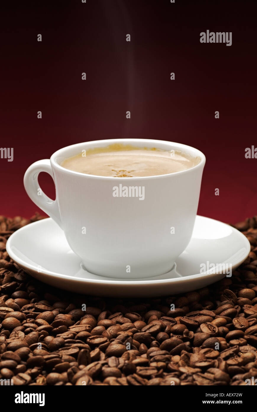 Dampfende Tasse Kaffee auf Kaffeebohnen Stockfoto