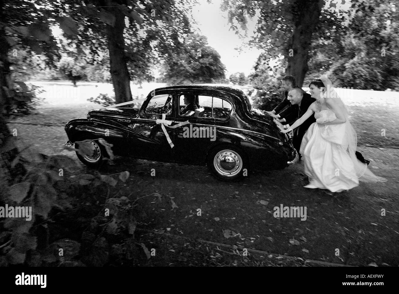 PIC von DAVID BURGES der Braut, Bräutigam und Bestman drücken Sie das kaputte Auto am Tag Hochzeit Stockfoto