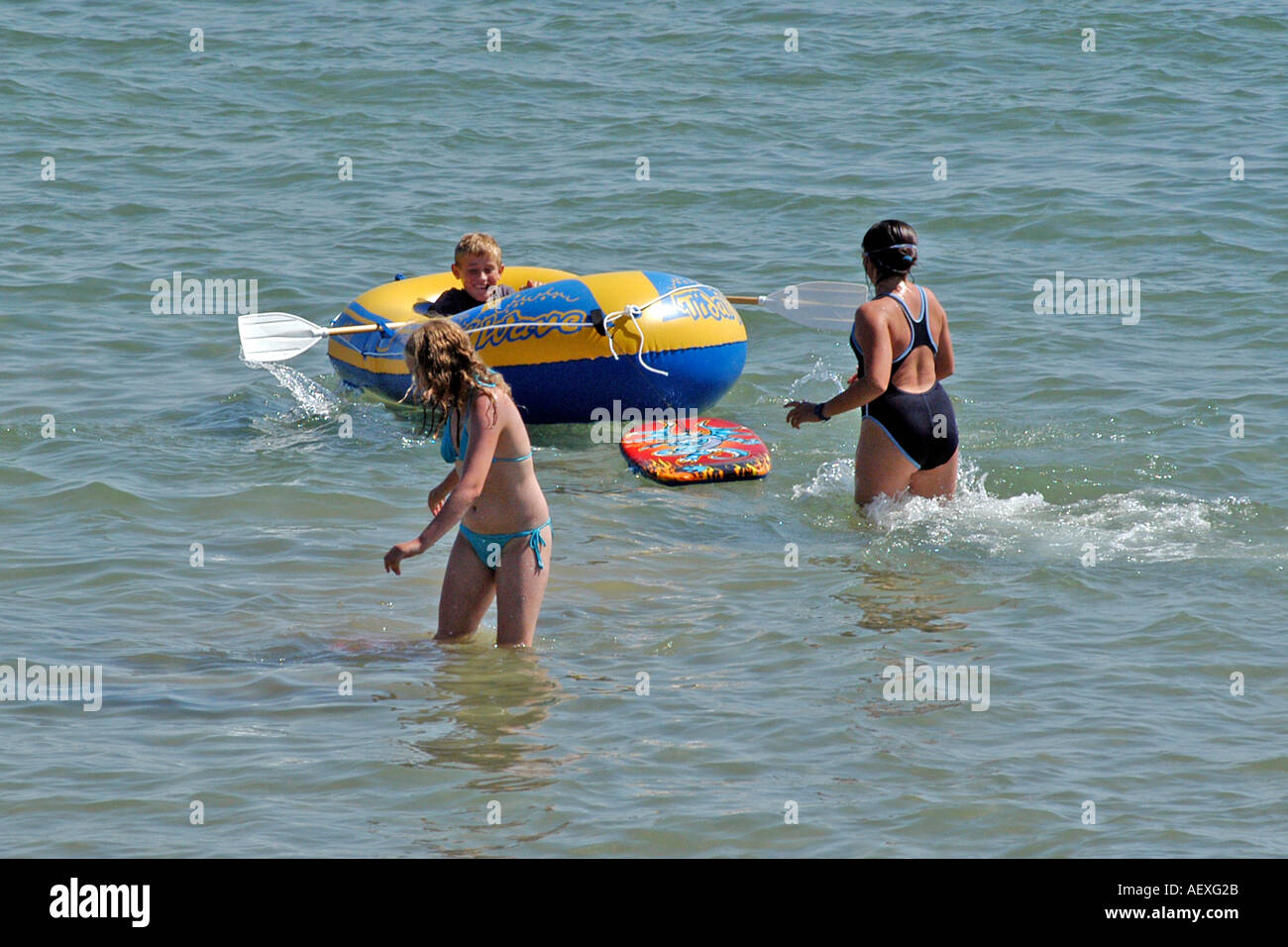 Menschen im Meer mit einem kleinen Schlauchboot in Bournemouth, Dorset. Stockfoto