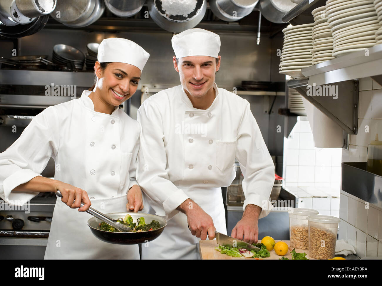 Männliche und weibliche Köche im Restaurantküche Stockfoto