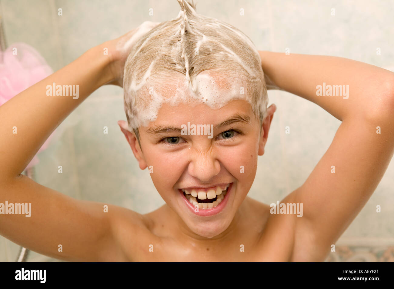 Junge Haarwäsche Haare in der Dusche Stockfoto