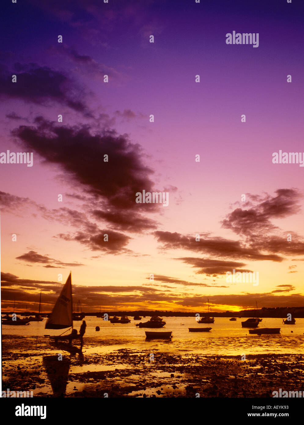 Sonnenuntergang am Mudeford, Hafen von Christchurch, Dorset mit Segelboot-Silhouetten Stockfoto