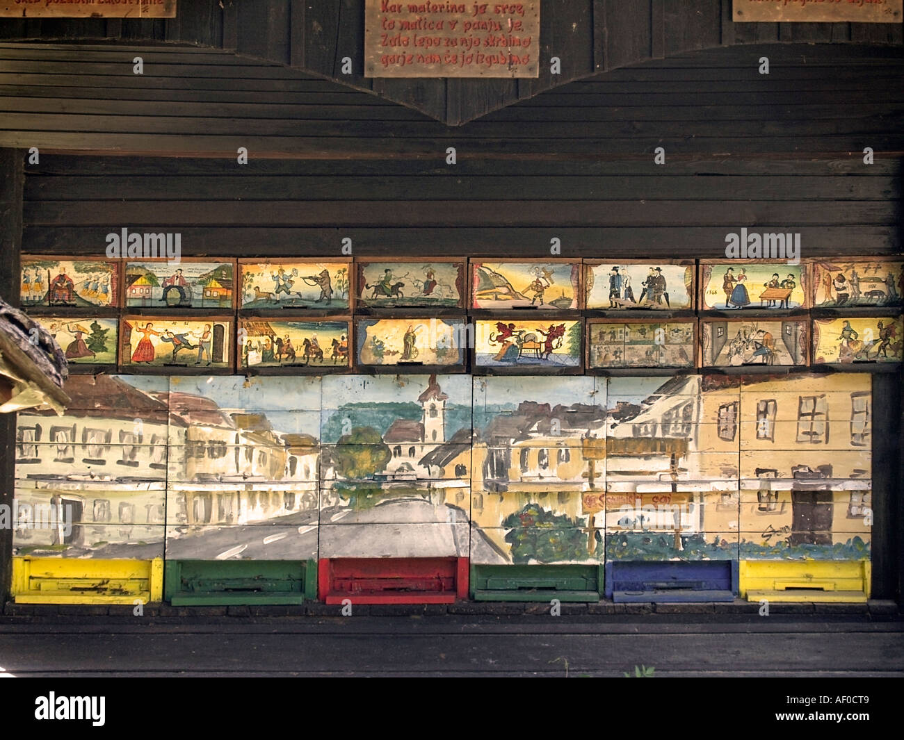 traditionelle Bienenhaus mit Bildern der Stadt Mozirje und verschiedenen historischen Szenen aus dem Leben in der Region in den Blumenpark Stockfoto