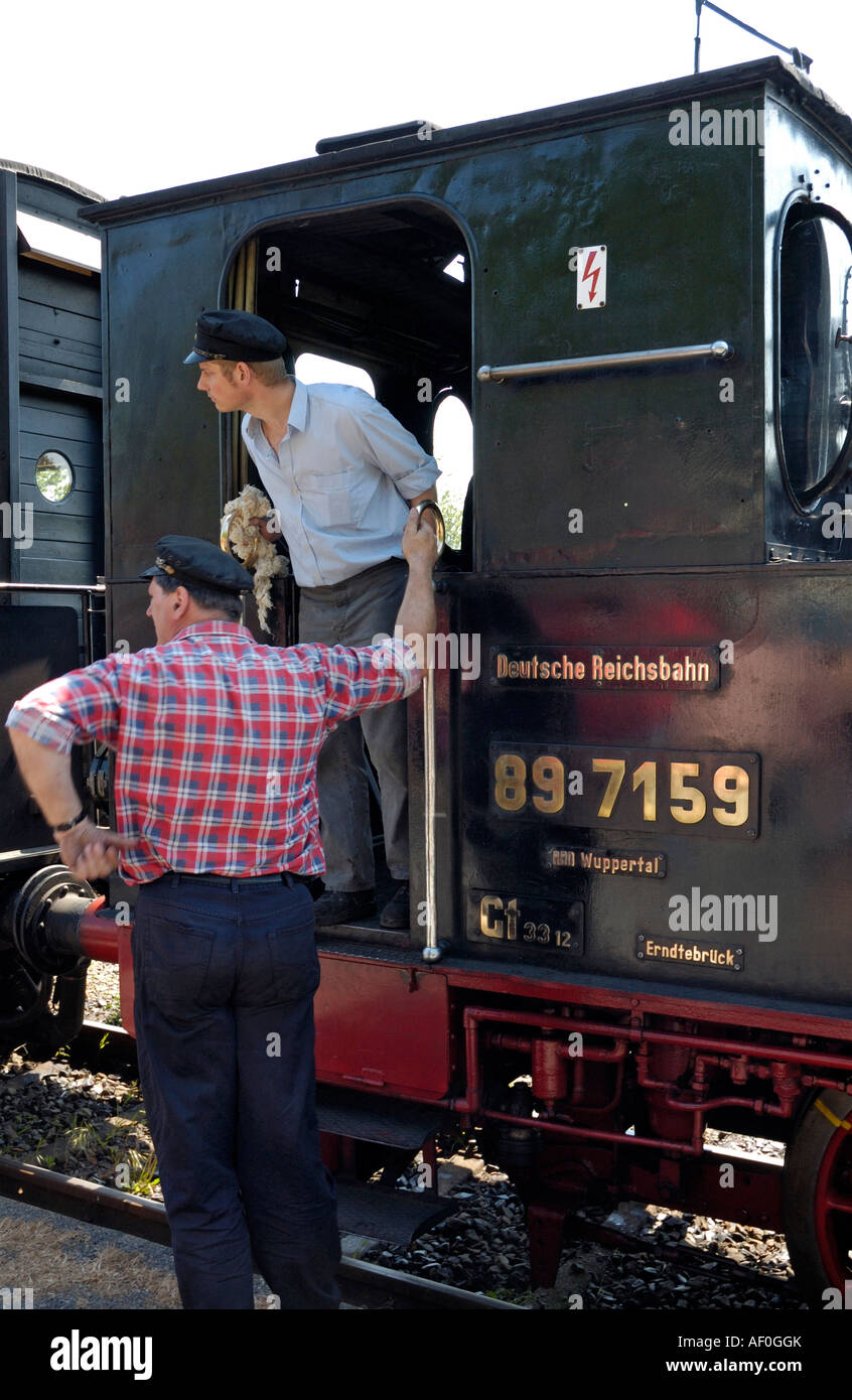 Eisenbahner warten auf Signal zu gehen, auf kleine erhaltene Dampflokomotive in Deutschland. Stockfoto