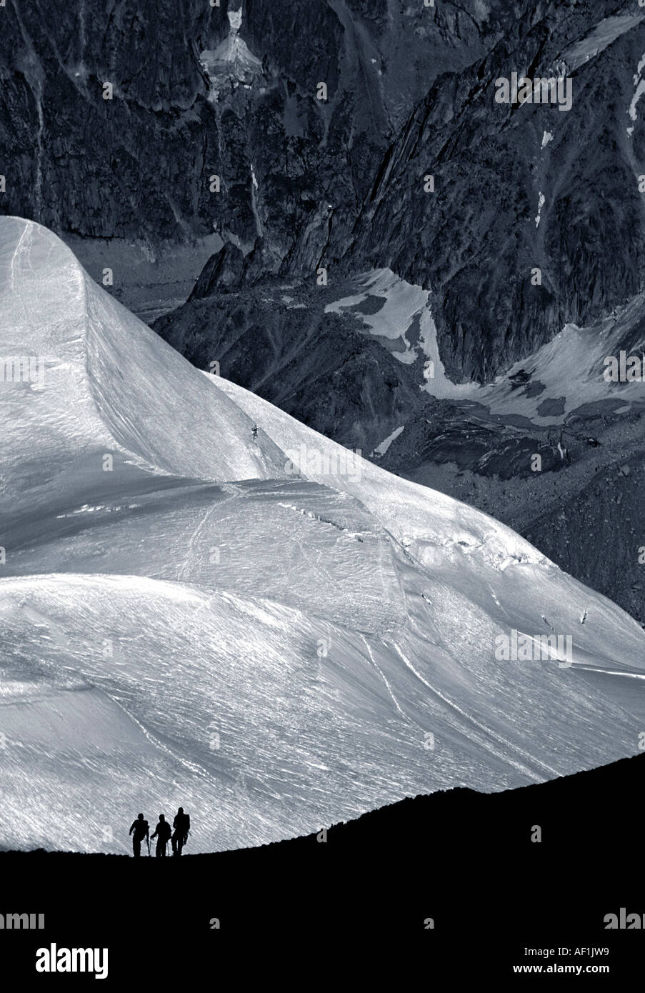Eine Gruppe von drei Kletterer einen Grat hoch in den französischen Alpen mit dem Vallée Blanche hinter absteigend Stockfoto