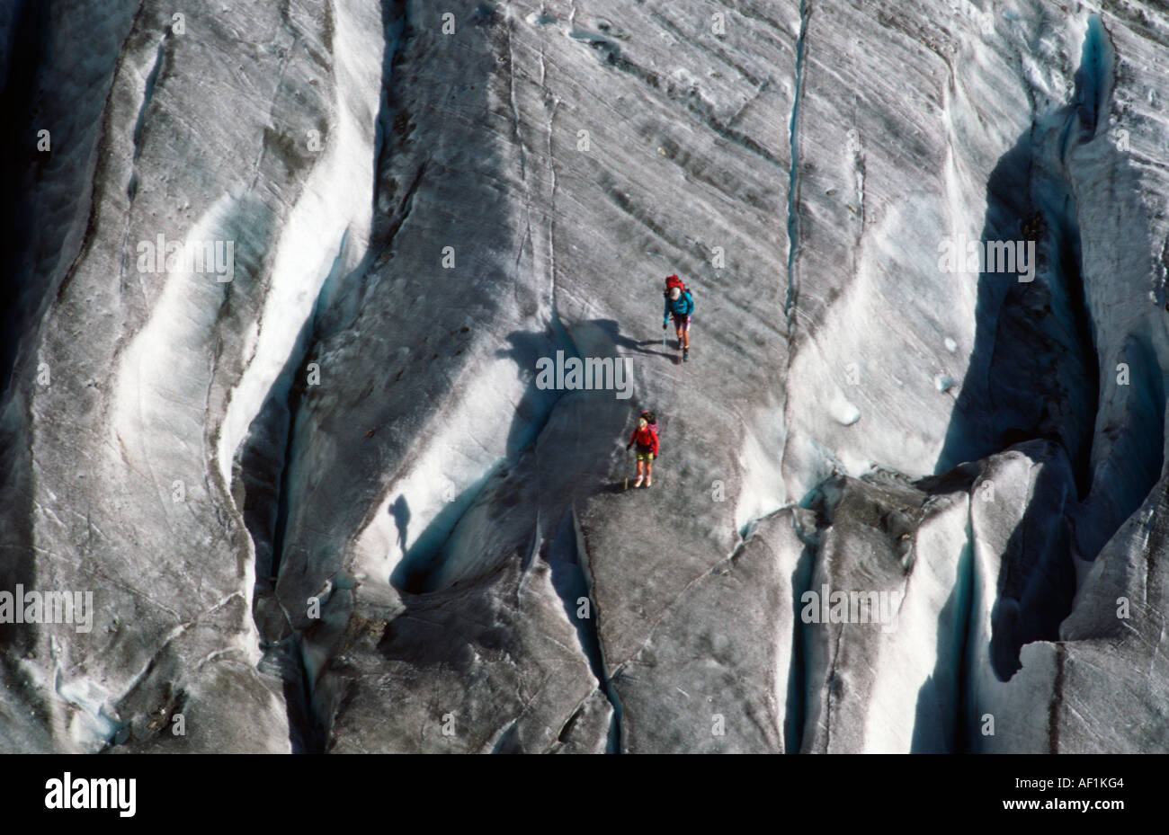 Zwei Kletterer unter Gletscherspalten auf einem Gletscher hoch in den französischen Alpen Stockfoto