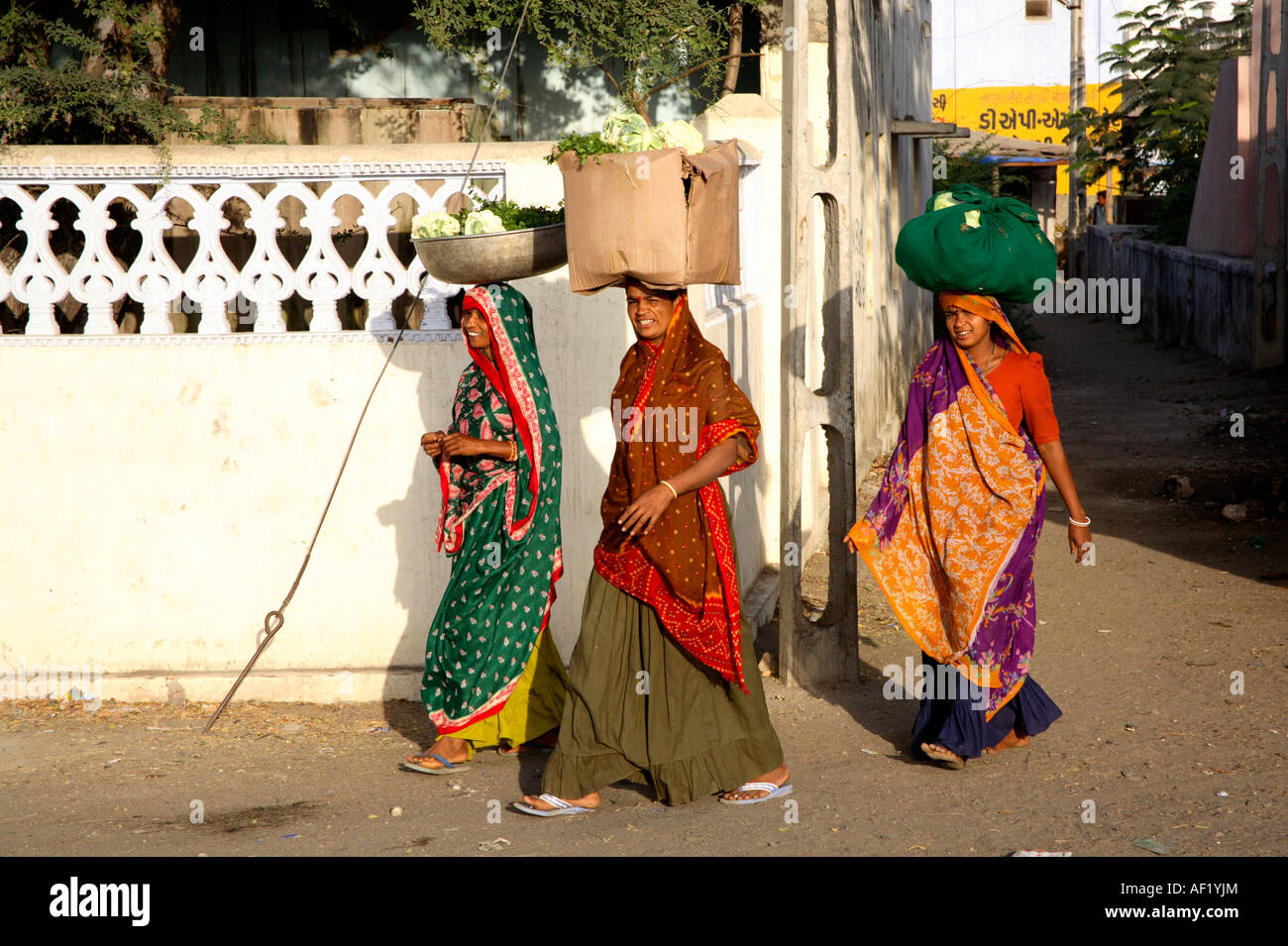 Frauen tragen Gemüsekörben auf ihre Köpfe, Mandvi, Kutch, Gujarat, Indien Stockfoto