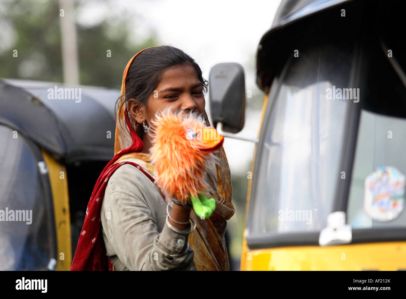 Junge indische Mädchen verkaufen Handpuppe im geschäftigen Verkehr, Pune, Indien Stockfoto