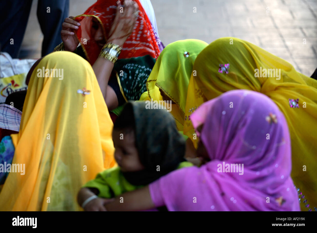 Junge indische Weibchen mit Köpfen bedeckt warten am Bahnhof Pune, Indien Stockfoto